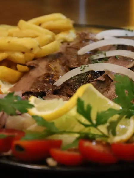 Grillteller mit Fleisch, Pommes, Bulgur und Salat