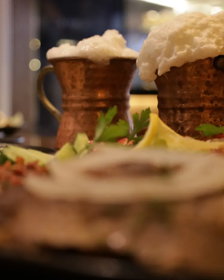 Türkische Gerichte mit Ayran im Kupferbecher